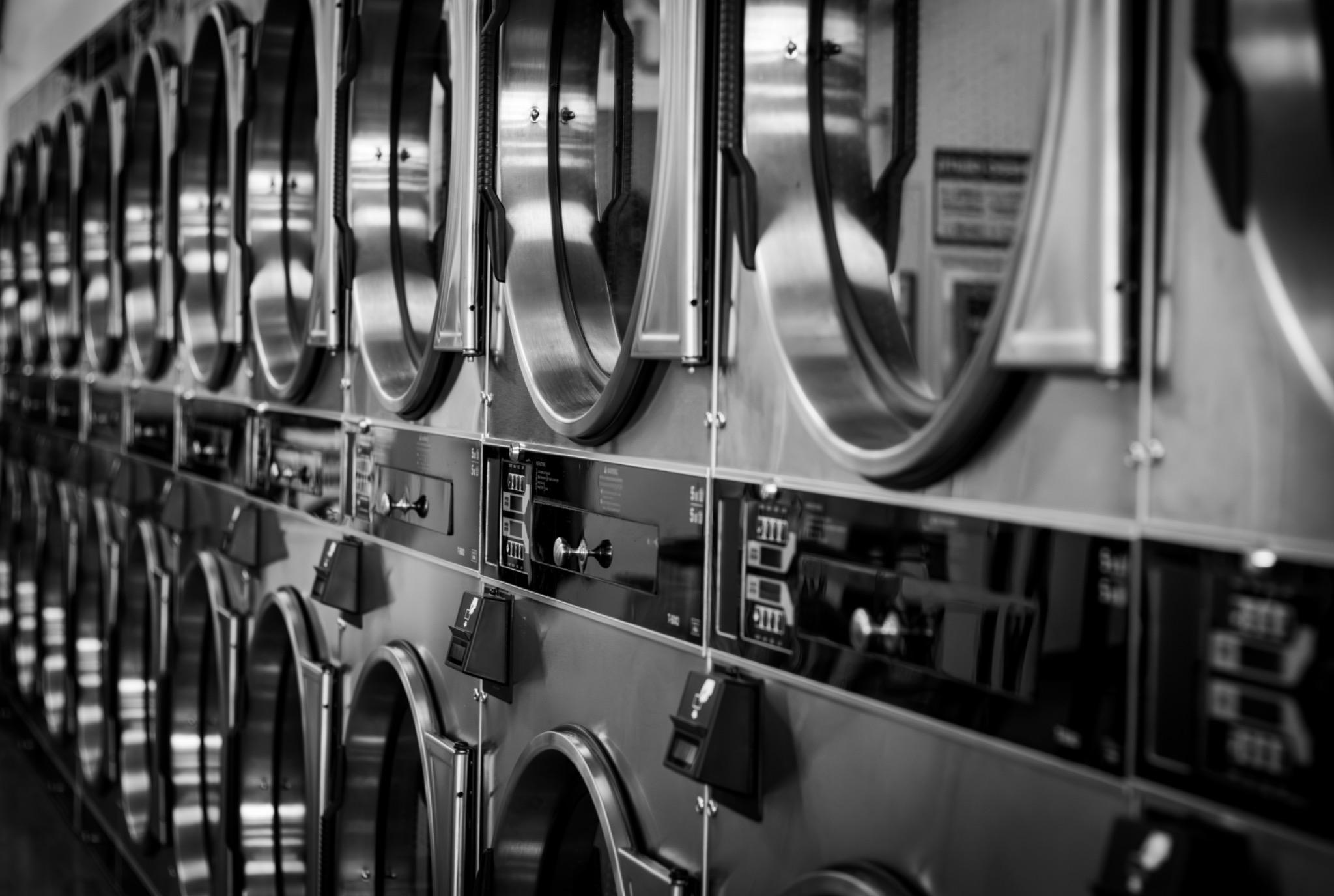 A repeating row of stainless-steel machines inside a Tucson laundromat