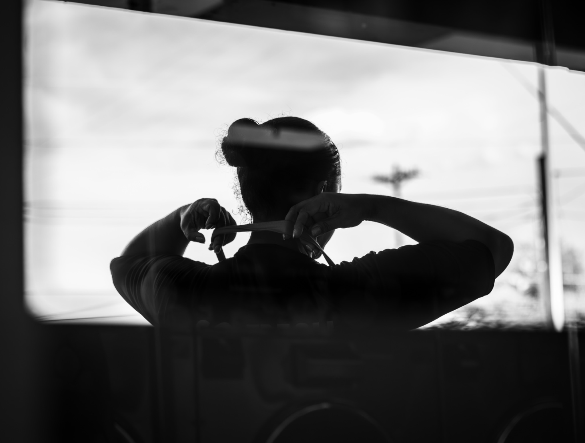 A worker tying an apron, seen as a reflection in a window